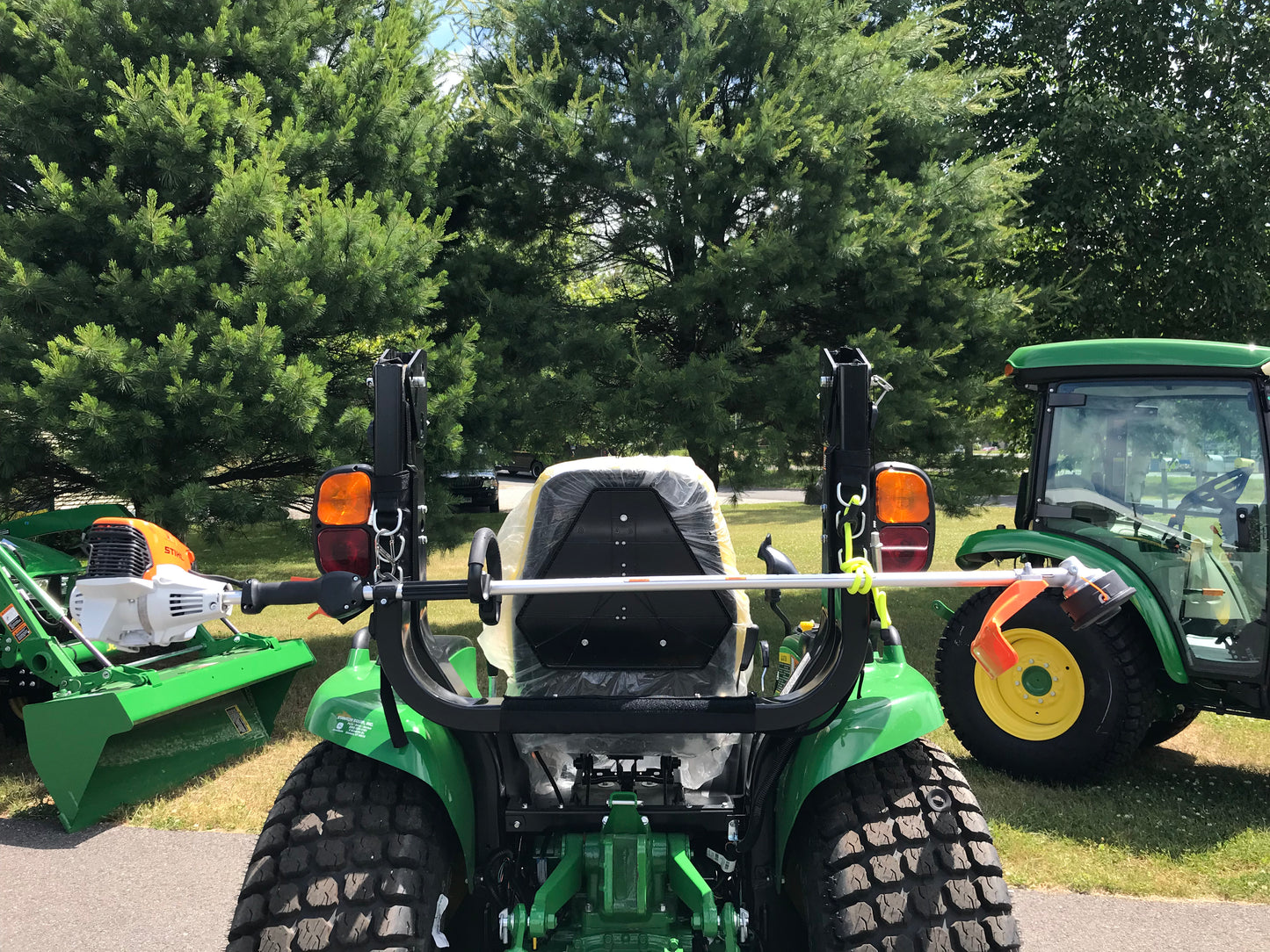 John deere compact tractor with rops bar folded having big tool rack rops rack Australia fitted with Stihl brush cutter 